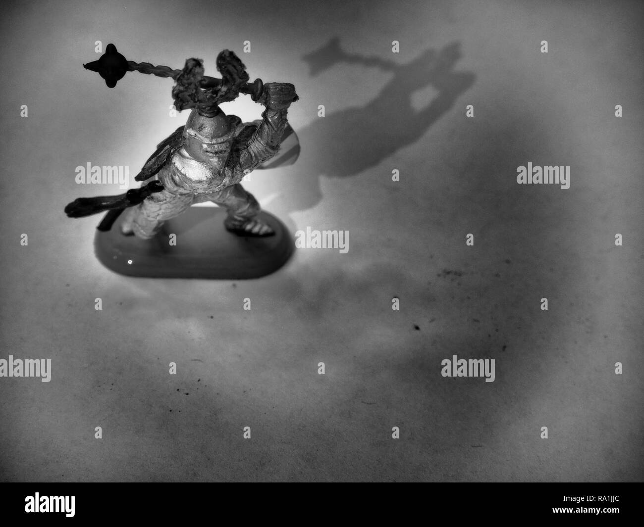 Black and White Image of Knight Wielding Flail on Wooden Table Stock Photo
