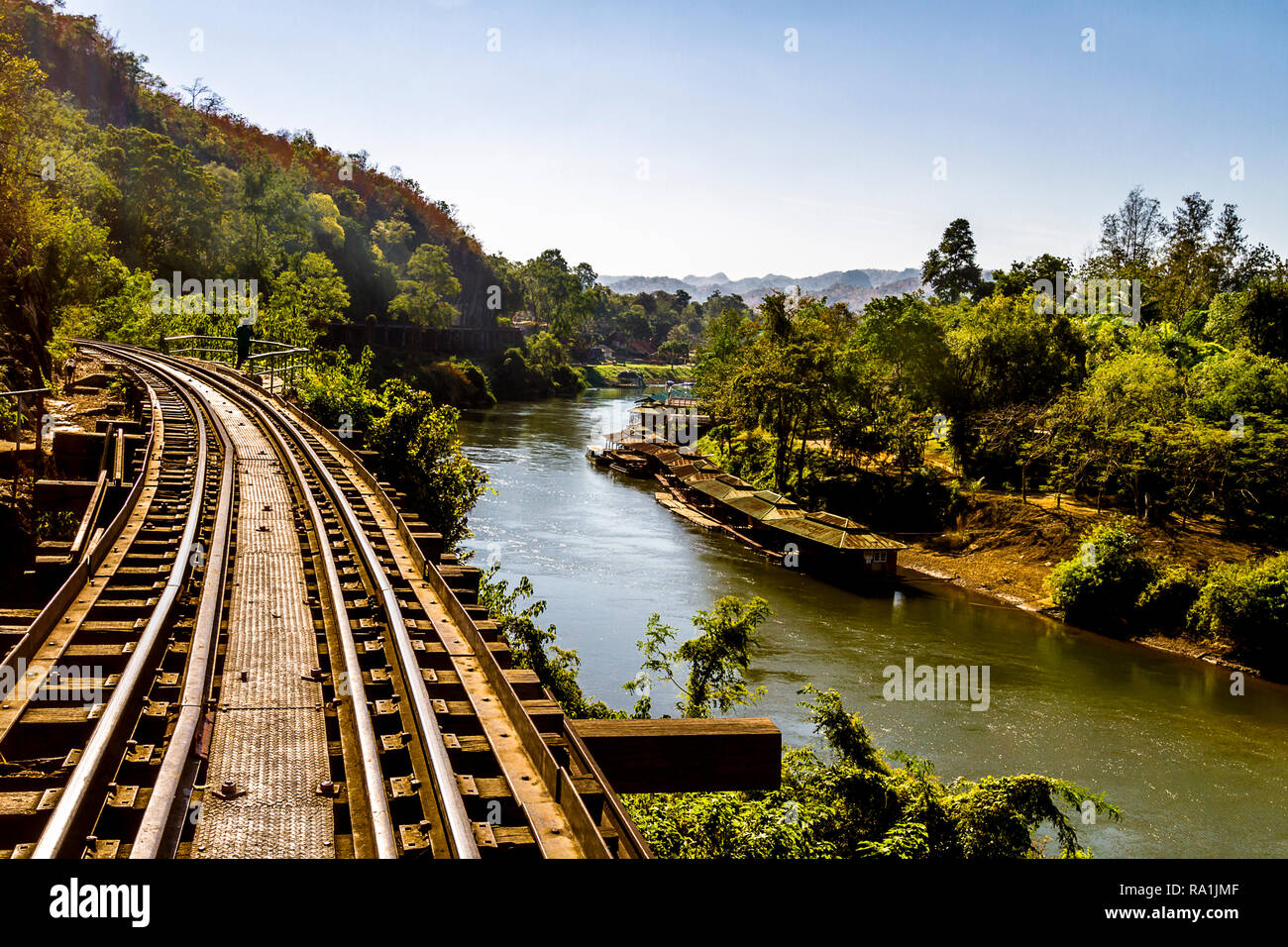 Railroad tracks running next too and above the river Kwai in Thailand. Stock Photo