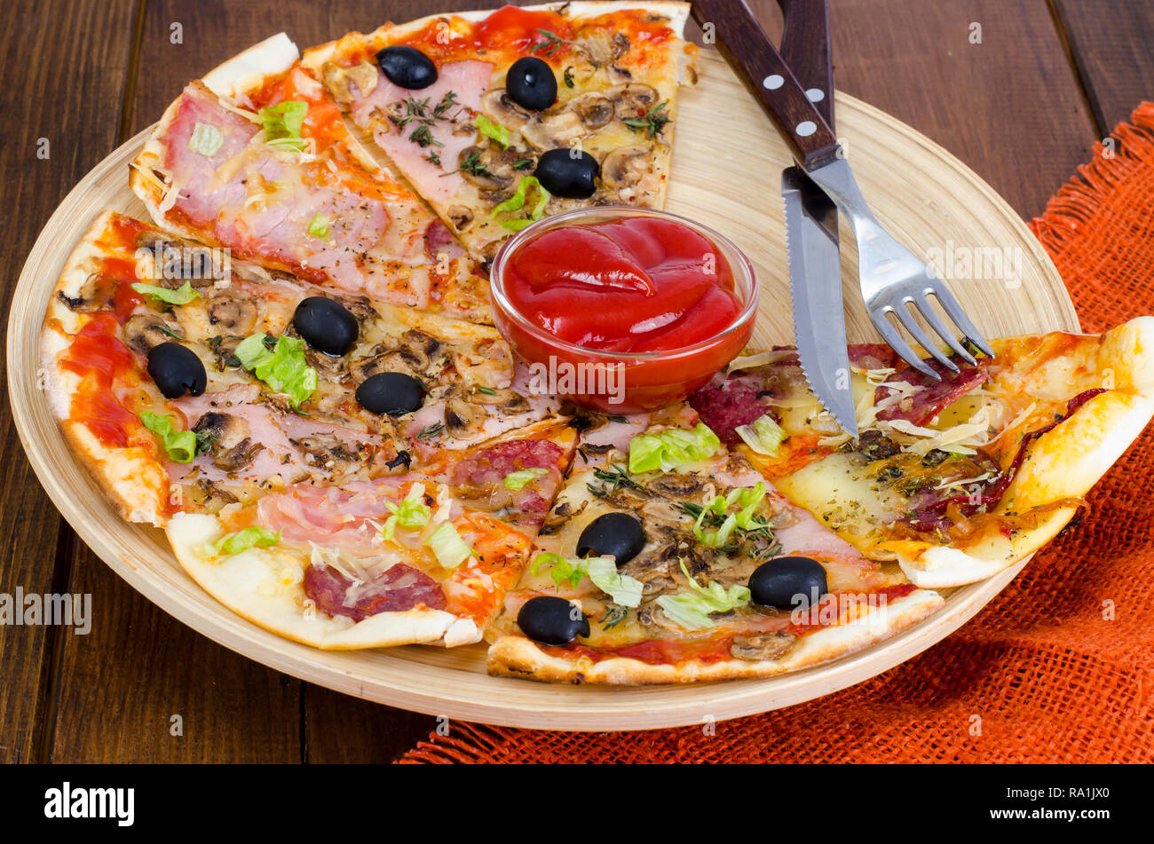 Six slices of pizza with different toppings on wooden board. Studio Photo Stock Photo