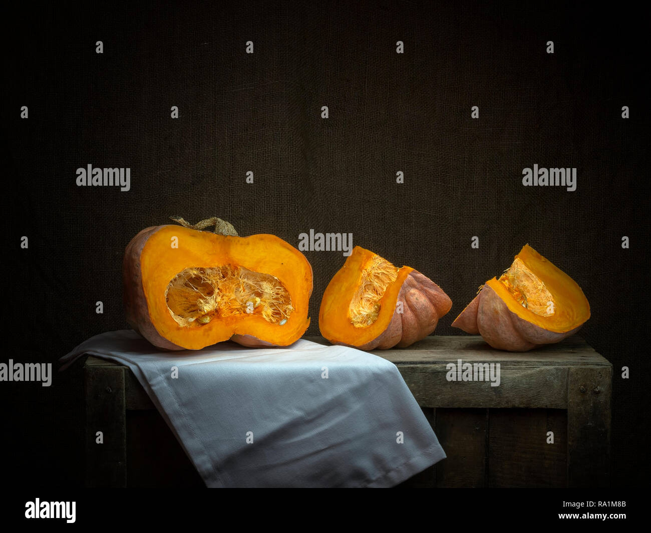 Acorn winter squash, pumpkin, sliced with cloth. Chiaroscuro, baroque style light painting. Stock Photo
