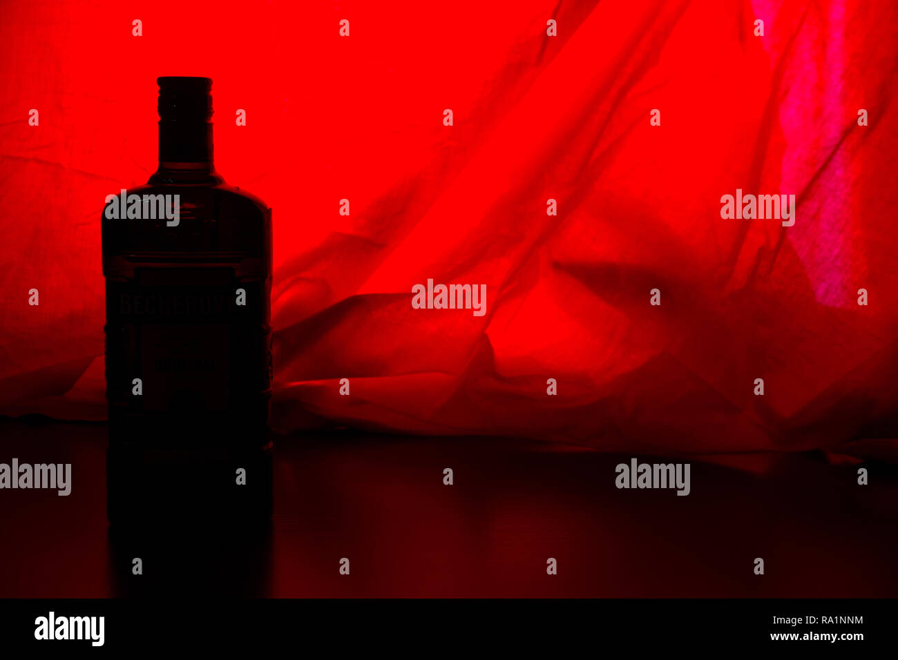 alcohol bottle on red backround. copy cpace Stock Photo
