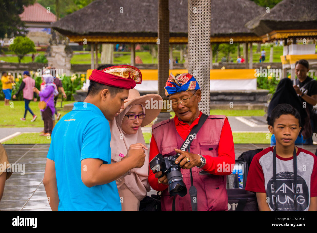 An old photographer of Bali citizen showing the photos that had been taken to his customers Stock Photo