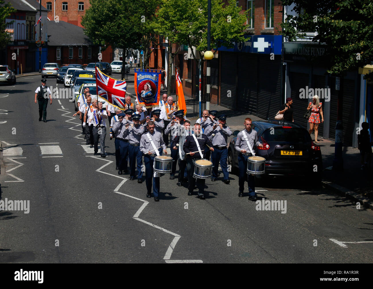 Marschsaison der protestantischen Oranierorden, hier durch ein katholisches Viertel von Belfast, Nordirland/ marching saison of the Orange Order (Loya Stock Photo