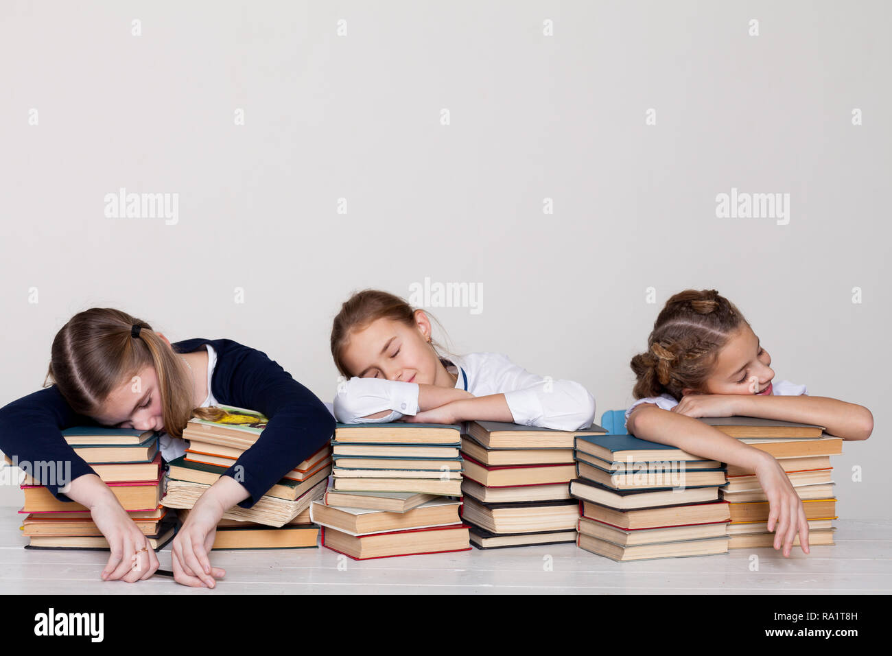 two girls schoolgirls sit with books at his desk on the lesson at ...
