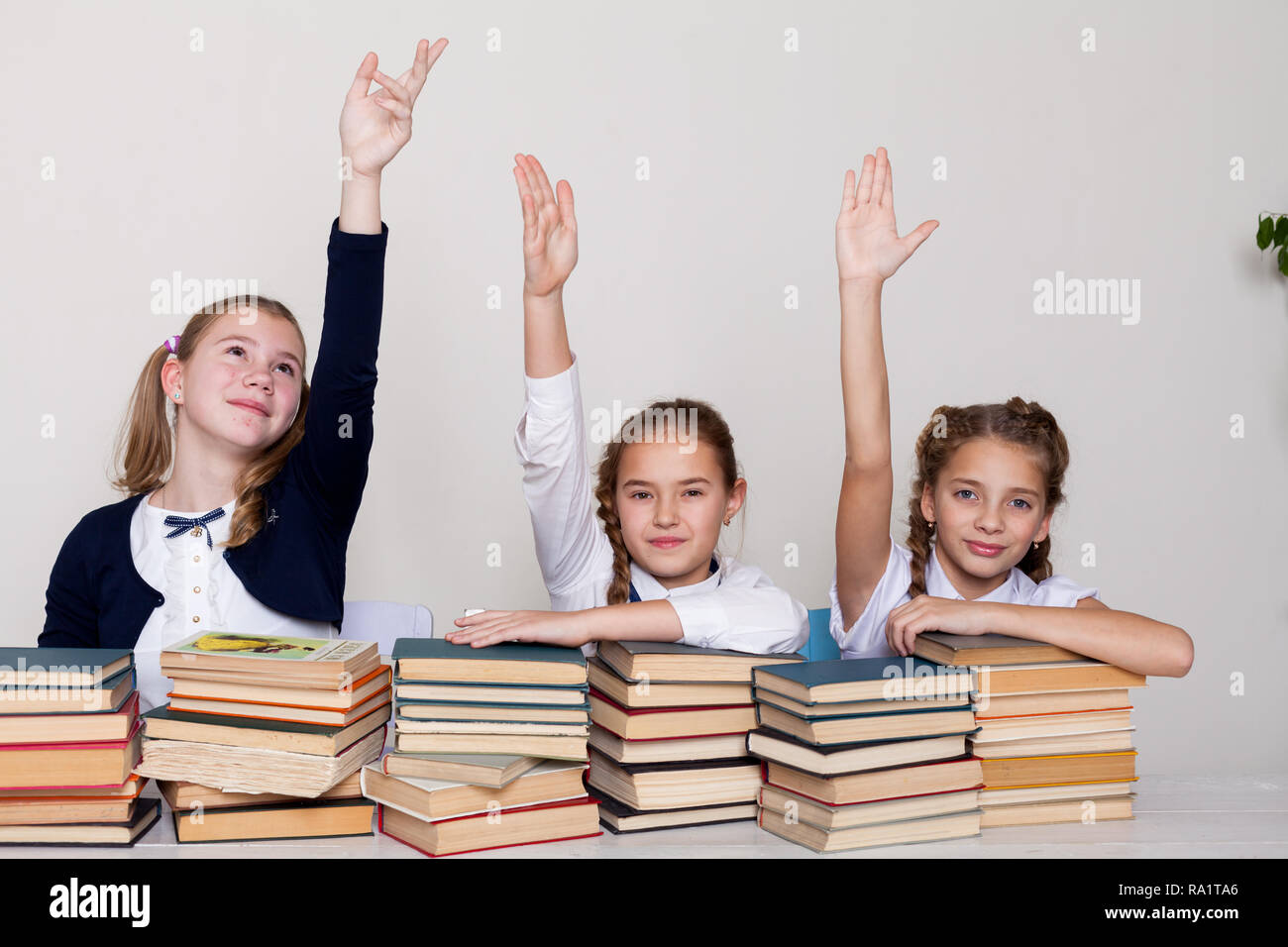 two girls schoolgirls sit with books at his desk on the lesson at ...