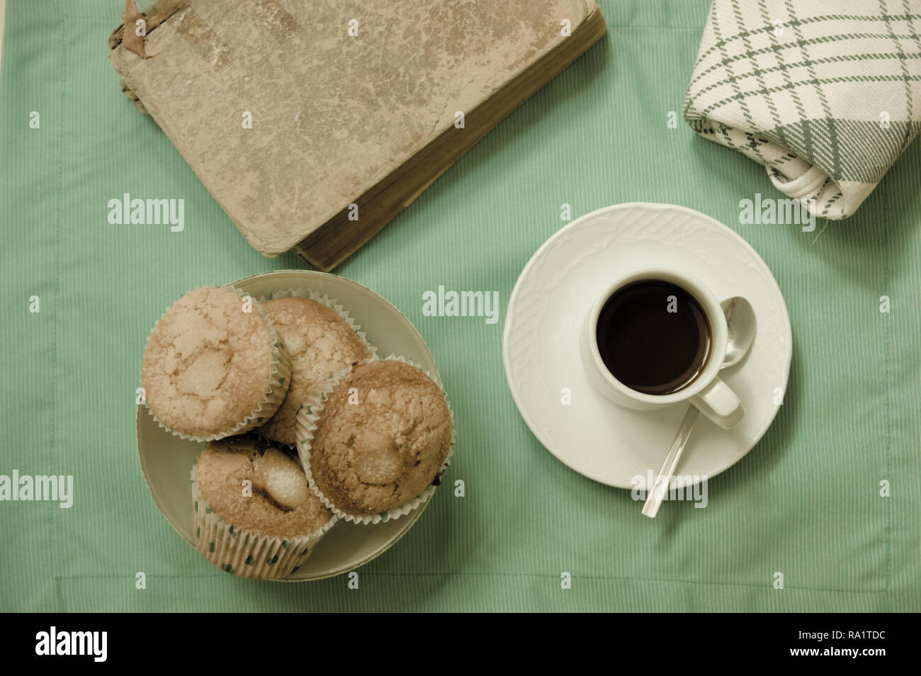 View from above with flat lay style, a snack with coffee, artisan muffins and a good book for relaxing moments Stock Photo