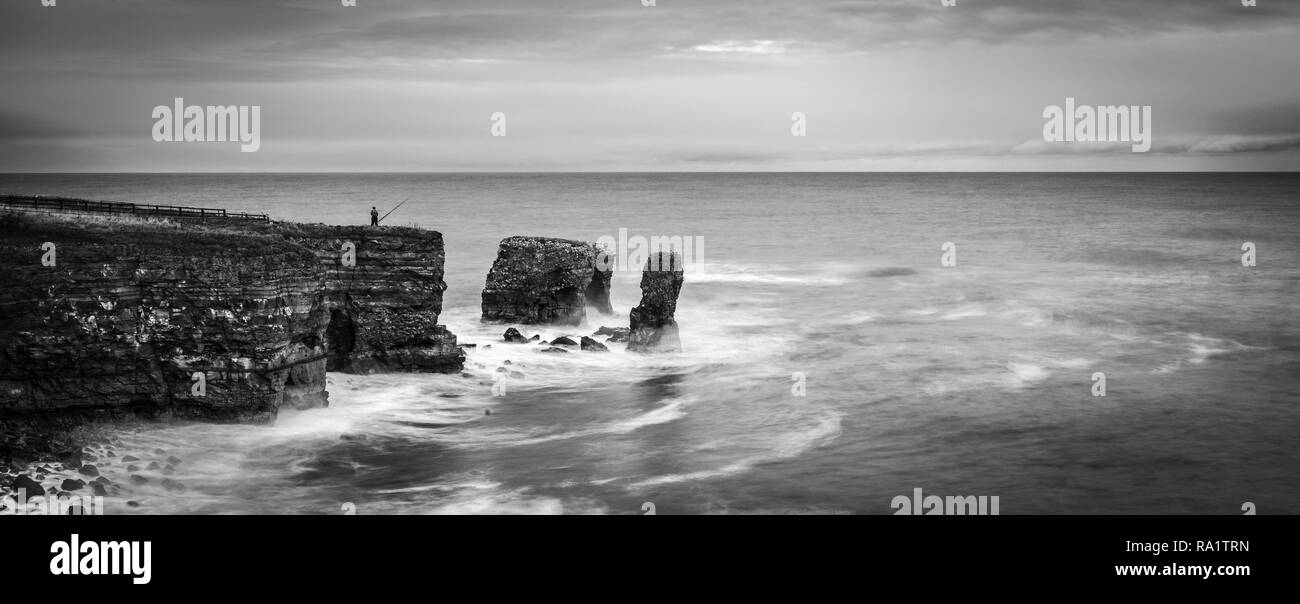 England, North East, Tyne&Wear, Sunderland, Whitburn, Fisherman. As the wild winter storm tides crash against the base of the cliffs, off the North Ea Stock Photo