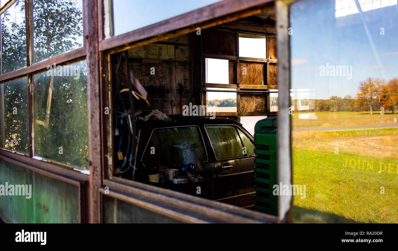 A decaying vehicle sits in an abandoned garage located in rural Michigan. Stock Photo