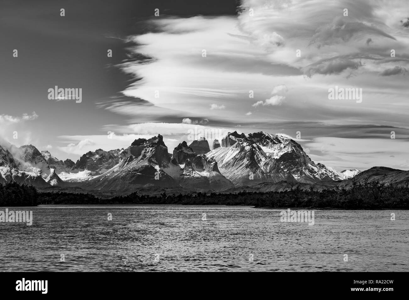 Black and white photograph of the Torres del Paine massif with the Cuernos del Paine in the foreground and a dramatic sky, Patagonia, Chile. Stock Photo