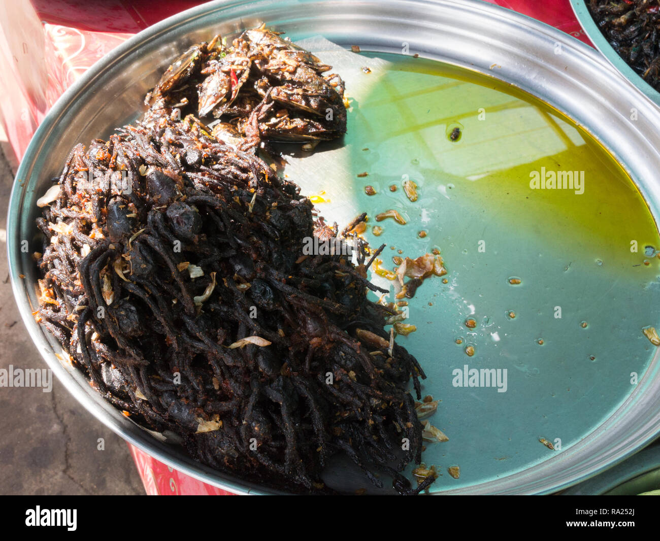 Plate of deep fried tarantulas and crickets for sale in Skuon Town Internationally reknown market Cambodia Asia also known as Spider Village Stock Photo