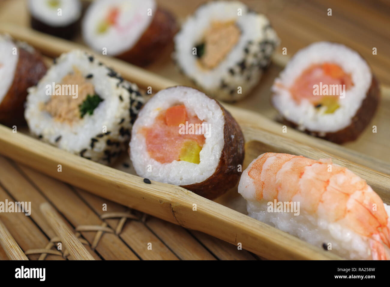 portion sushi and wooden hopsticks on plate Stock Photo