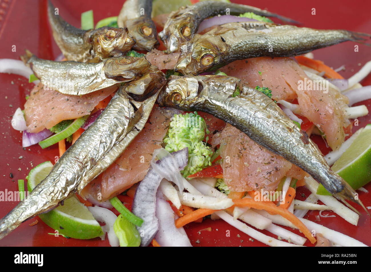 smoked salmon and sprats with vegetables and lemon Stock Photo