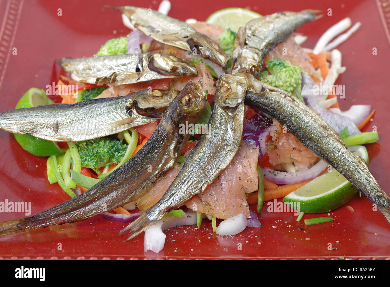 smoked salmon and sprats with vegetables and lemon Stock Photo