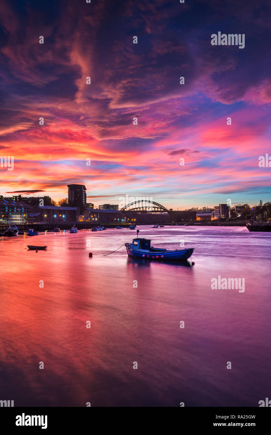 River Wear Fish Quay towards the iconic Wearmouth bridge, fishing boats in foreground, sunset producing a stunning array of colours & reflections Stock Photo