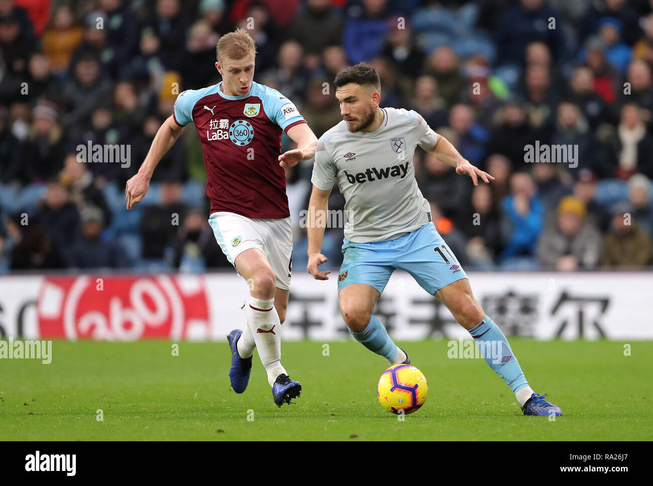 Burnley's Ben Mee (left) and West Ham United's Robert Snodgrass battle for the ball during the Premier League match at Turf Moor, Burnley. Stock Photo