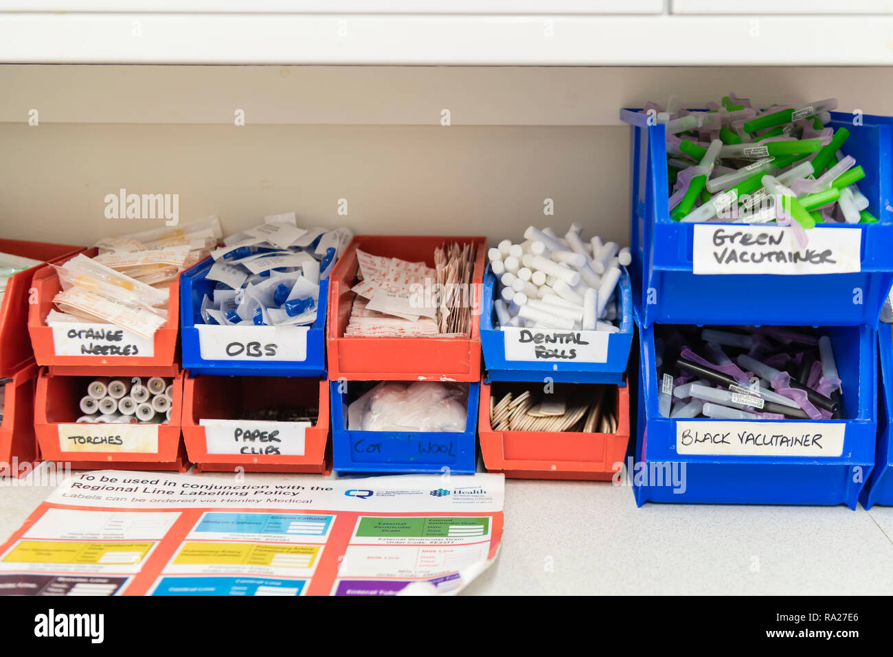 Plastic tubs containing medical equipment, including butterfly needles, vacutainers, torches etc for taking blood samples in a hospital treatment room Stock Photo