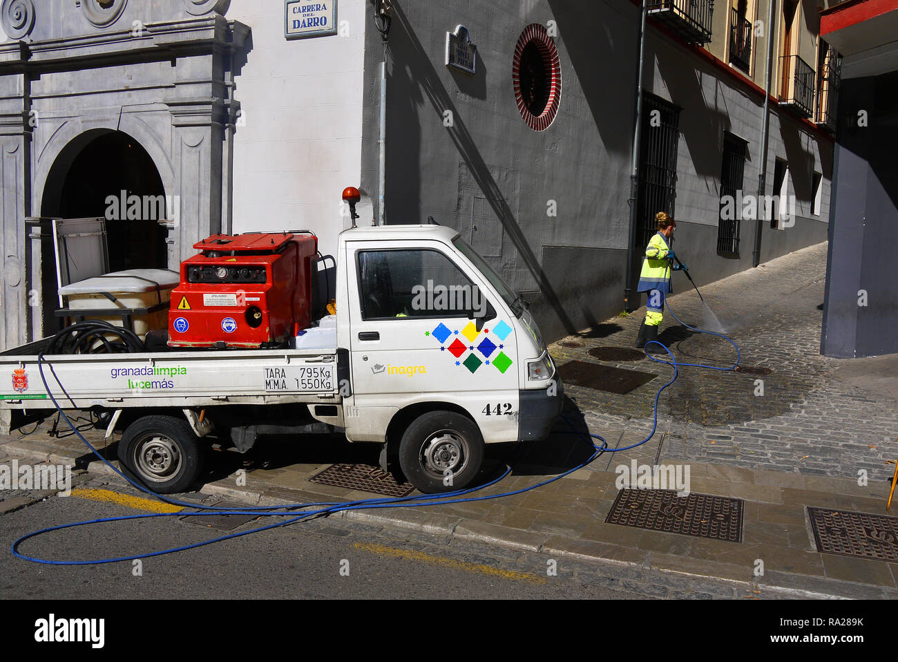 A street cleaner at work with a pressure washer in Granada, Spain. Stock Photo