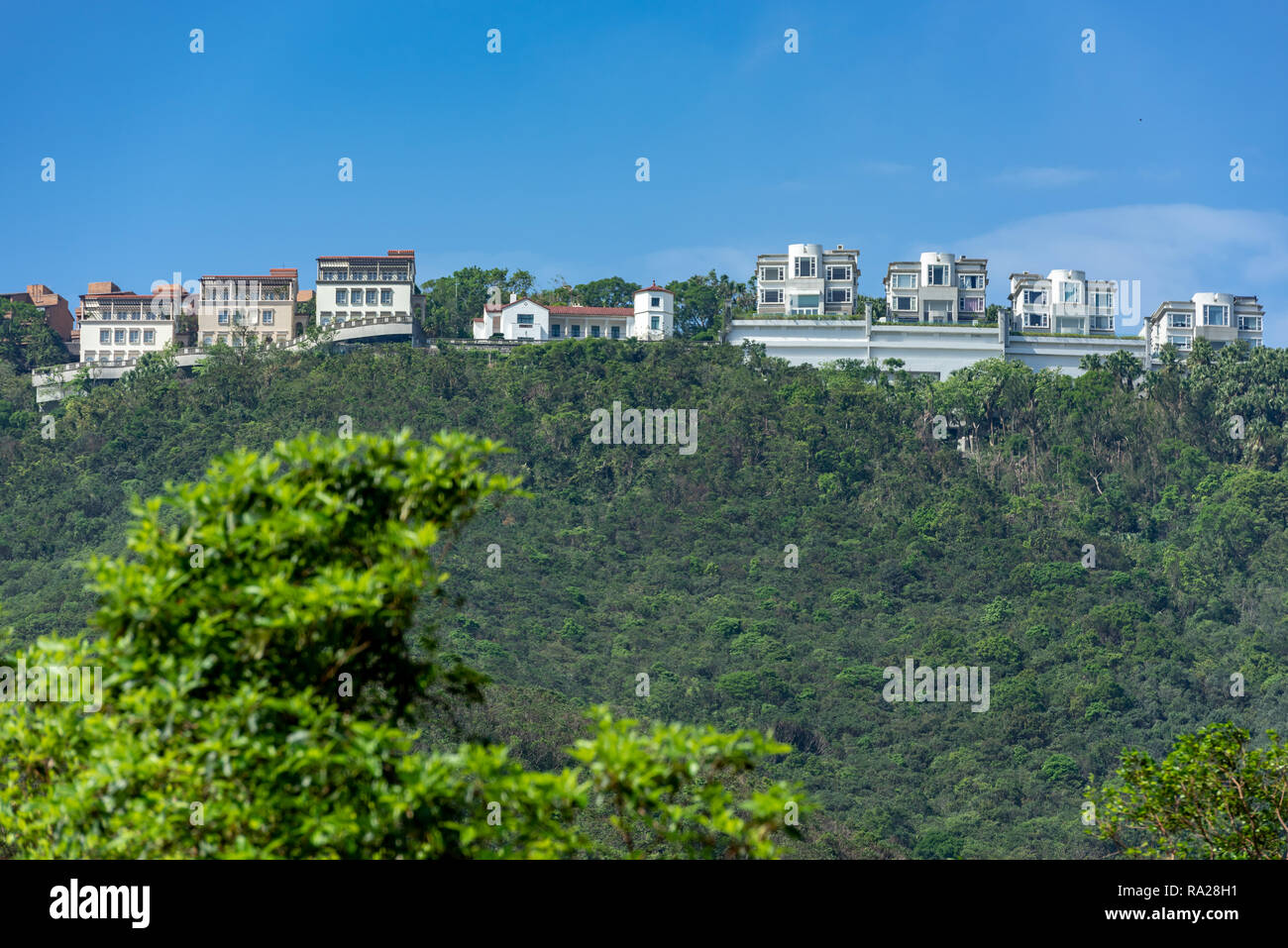 These luxurious homes along Peak Road in Hong Kong have spectacular views over Aberdeen Country Park, the twin reservoirs, and Deep Water Bay. Stock Photo
