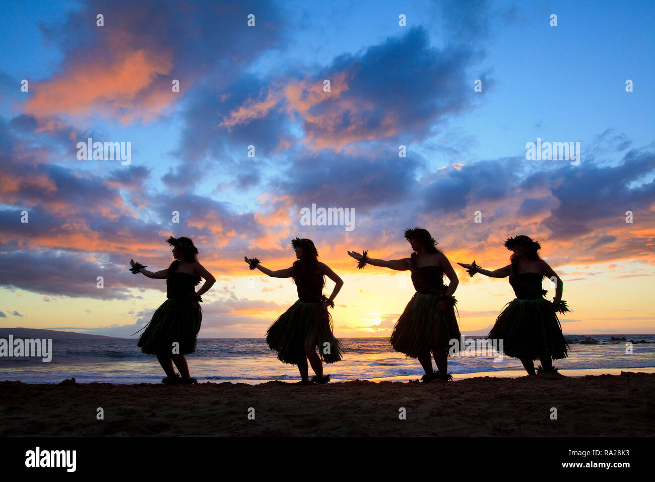 Four hula dancers with a spectacular sunset at Palauea Beach, Maui, Hawaii. Stock Photo