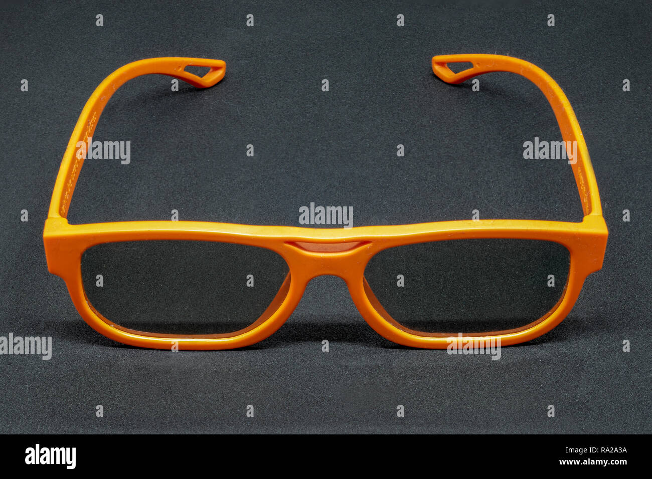Orange 3 Dimensional glasses on a dark grey background Stock Photo