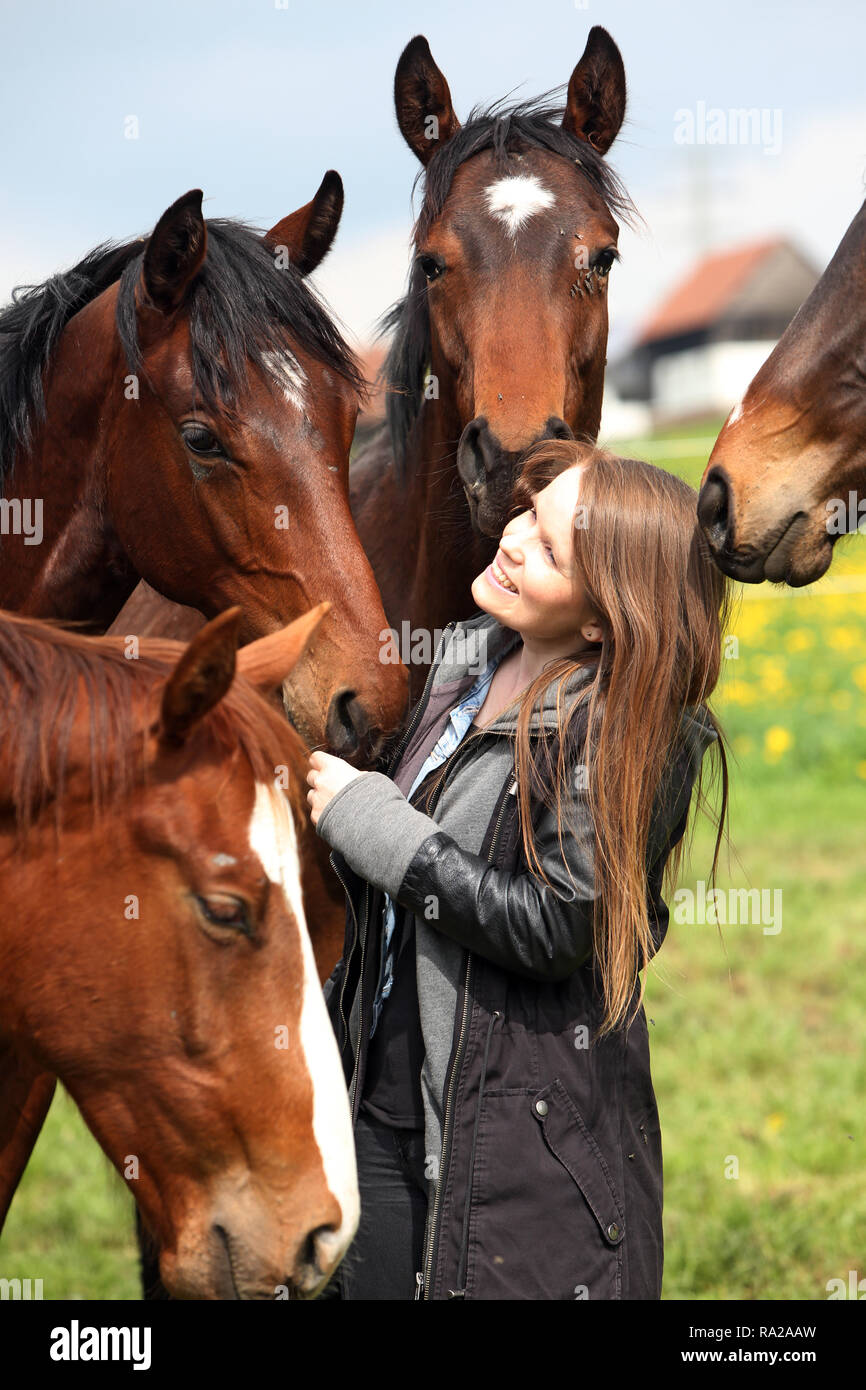 24.04.2018, Hessen, Gestuet Etzean, junge Frau wird auf der Weide von neugierigen Pferden umringt. 00S180424D197CARO.JPG [MODEL RELEASE: NO, PROPERTY  Stock Photo