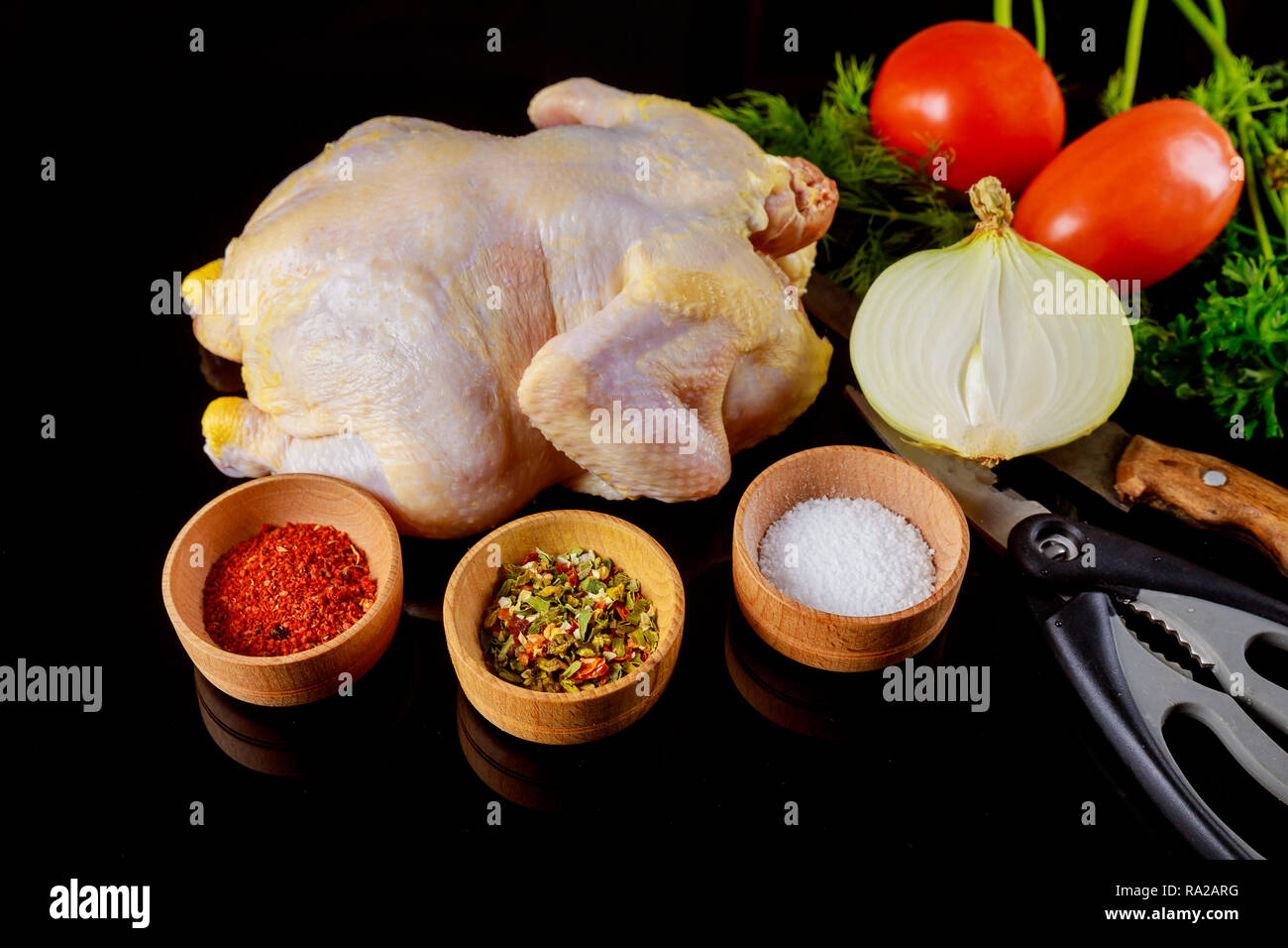 Marinated raw chicken ready for grilling on a dark background. Raw