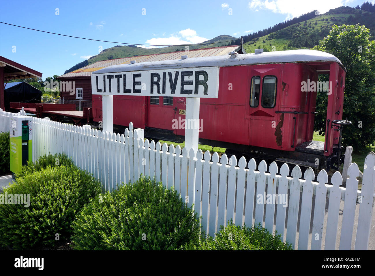 Little River Station Sign in Front of the Former Railway Station, with an Old Carriage standing abandoned on the Tracks Stock Photo