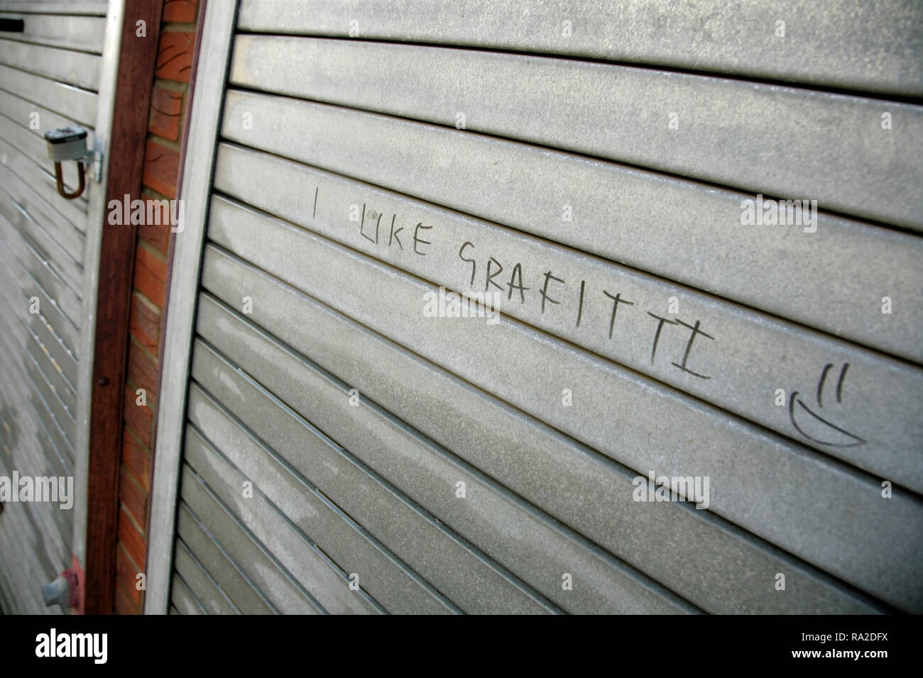 'I like graffiti' graffiti, with incorrect spelling, on shuttered shopfront. Stock Photo