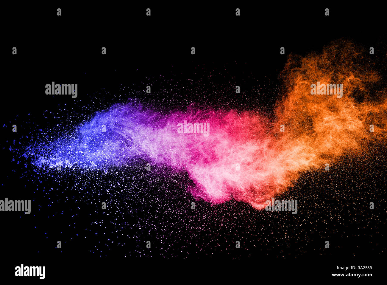 color powder explosion cloud isolated on black background. Freeze motion of color dust  particles splash. Stock Photo