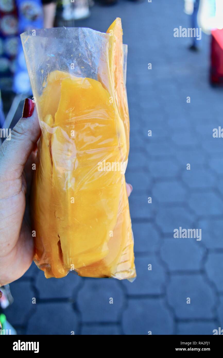 Thick slices of sweet mango sold on street corners as snack street food in Guatemala Stock Photo
