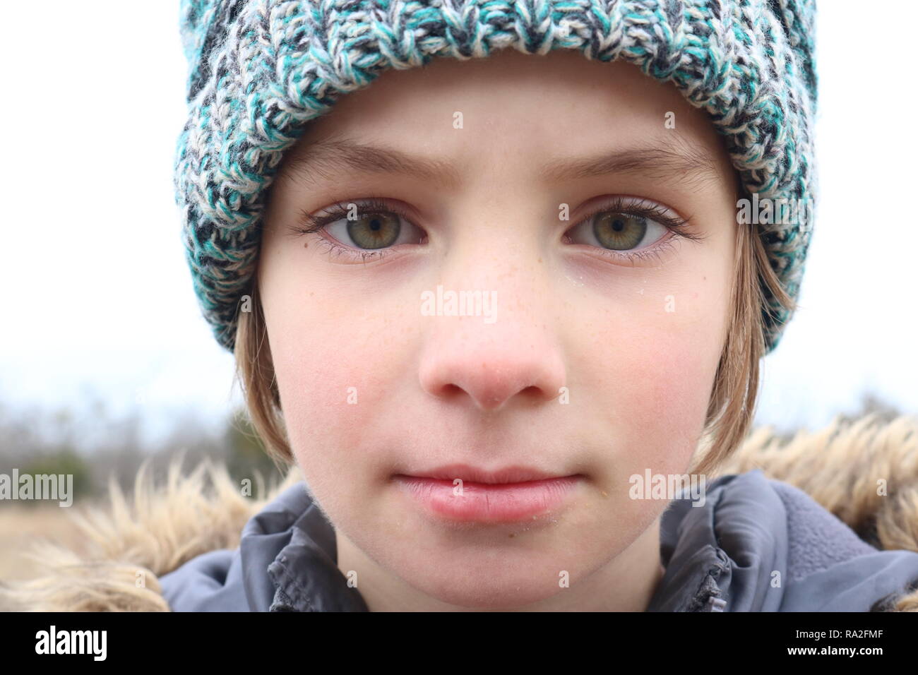 Portrait of a girl with intense green eyes wearing a cap in the winter cold Stock Photo