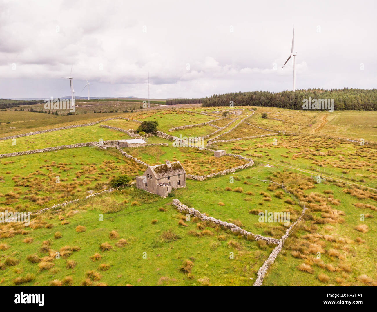 An aerial view of  wind turbines and an abandoned farm house between the towns of Spiddal and Moycullen in County Galway, Ireland Stock Photo