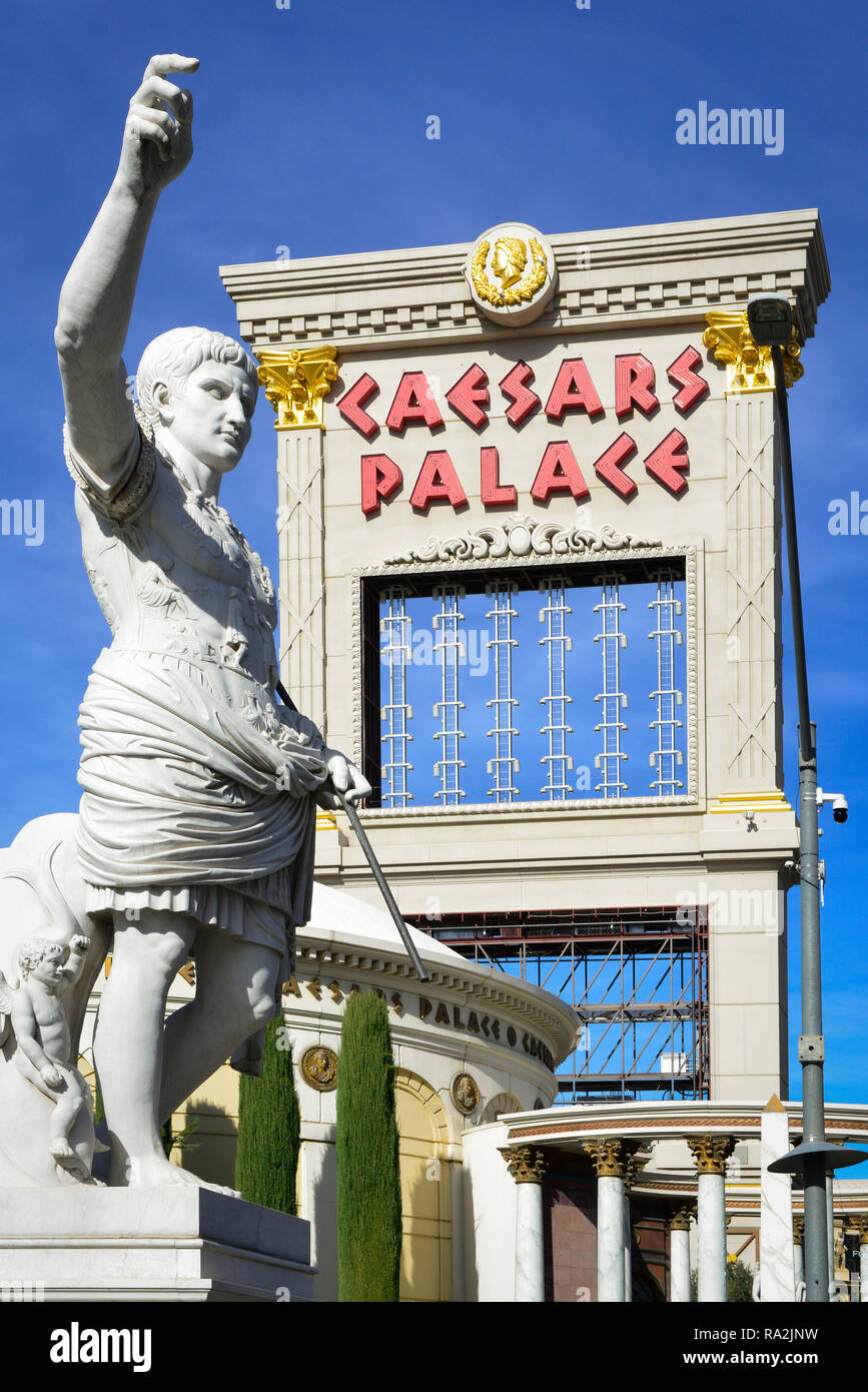 A marble statue of Caesar holding up his hand in front of the entrance