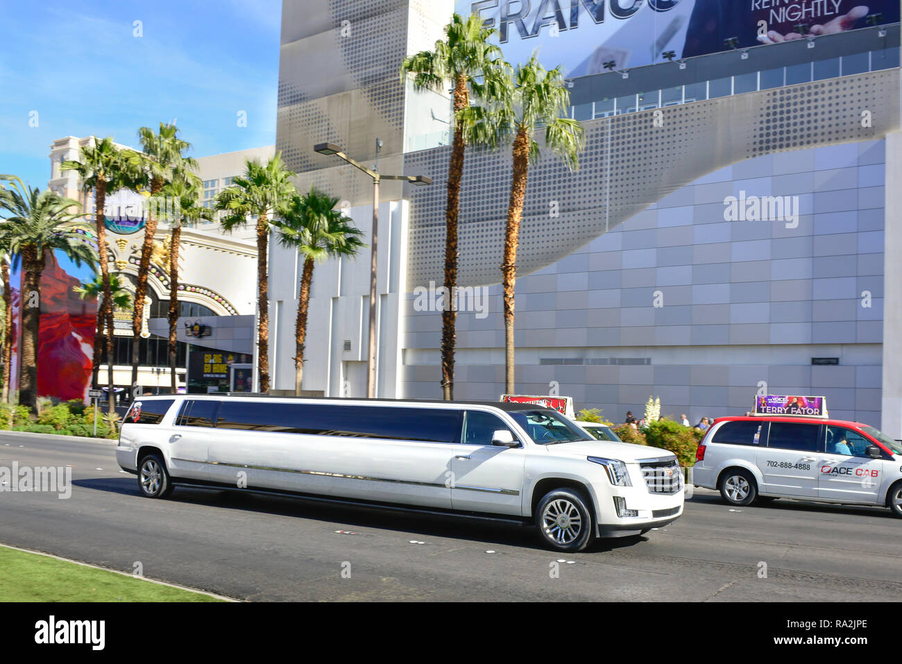 A white Cadillac stretch limousine traveling on the Las Vegas Strip in front of the Linq Hotel and Casino in Las Vegas, NV on a sunny day Stock Photo
