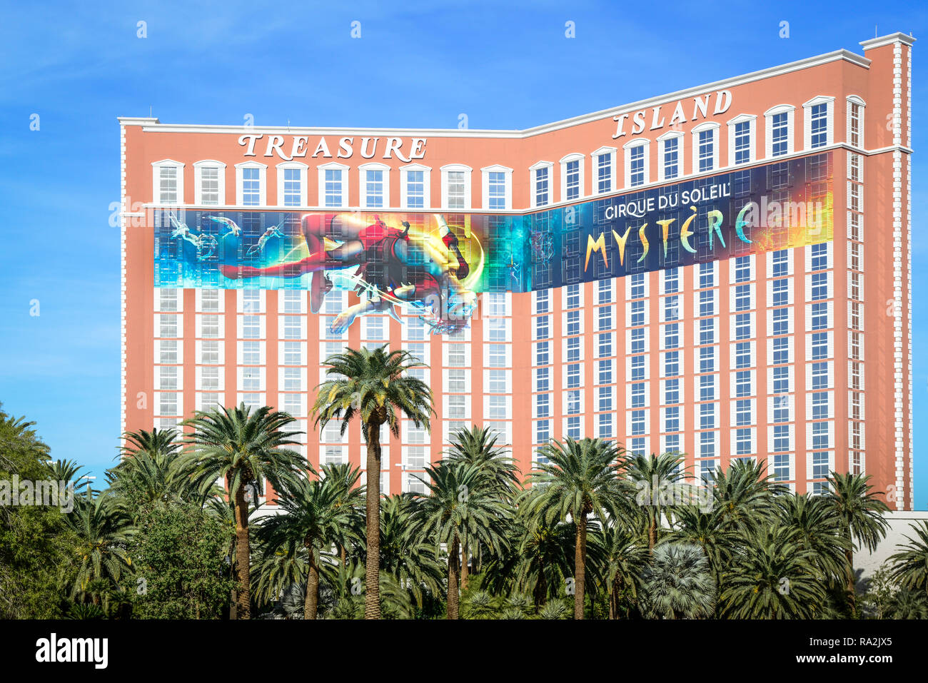 The Treasure Island Resort Hotel and Casino amongst the Palm trees advertising for the Cirque du Soiell's Mystere show on the strip in Las Vegas, NV Stock Photo