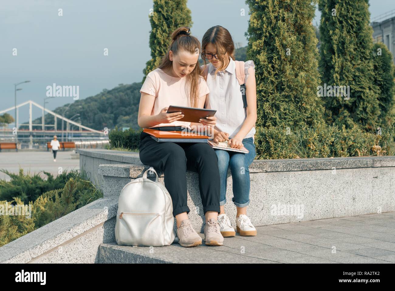 Outdoor portrait of two young beautiful girls students with backpacks ...