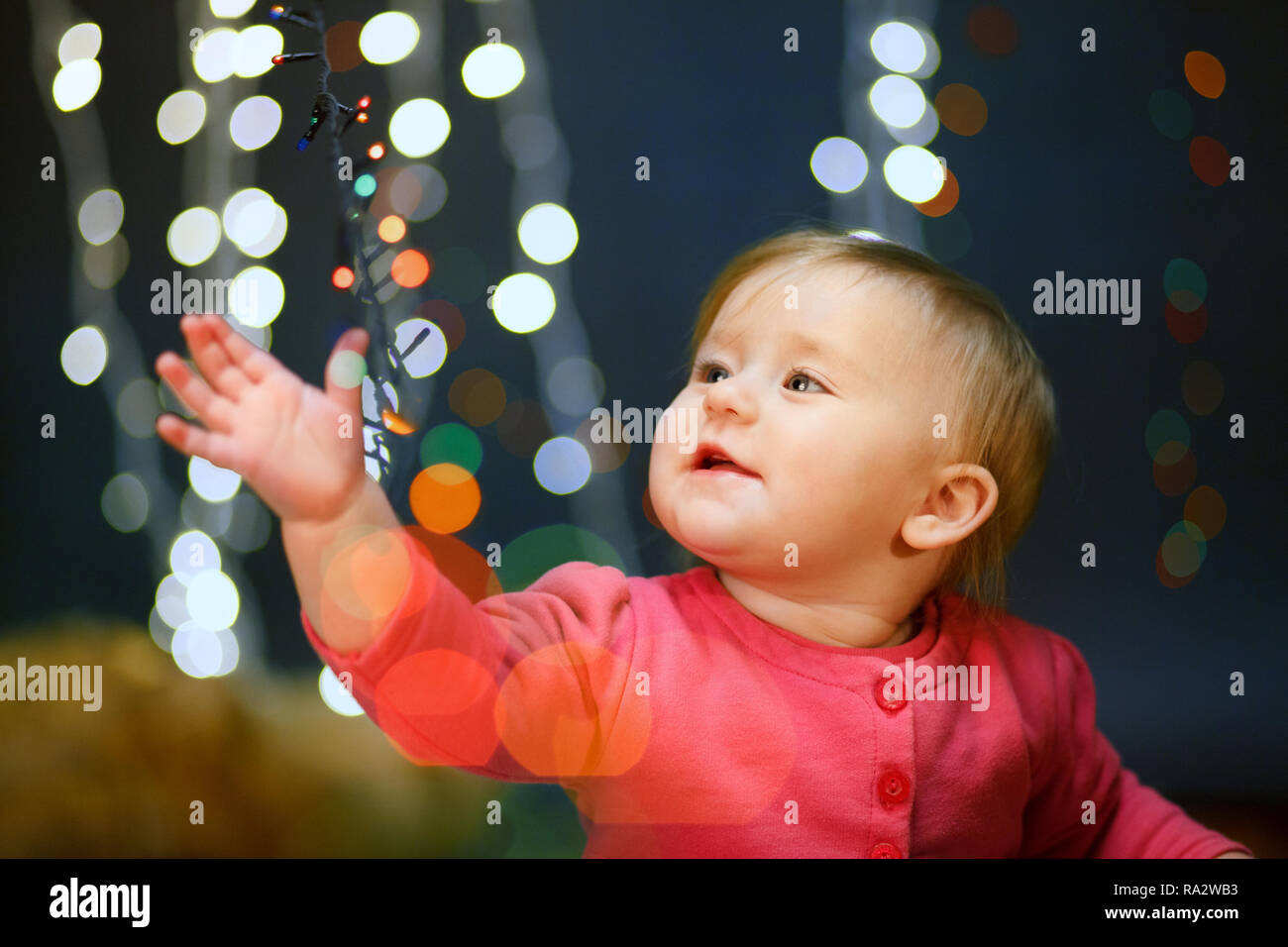 Portrait of a little girl in a pink dress in the studio. Lights ...