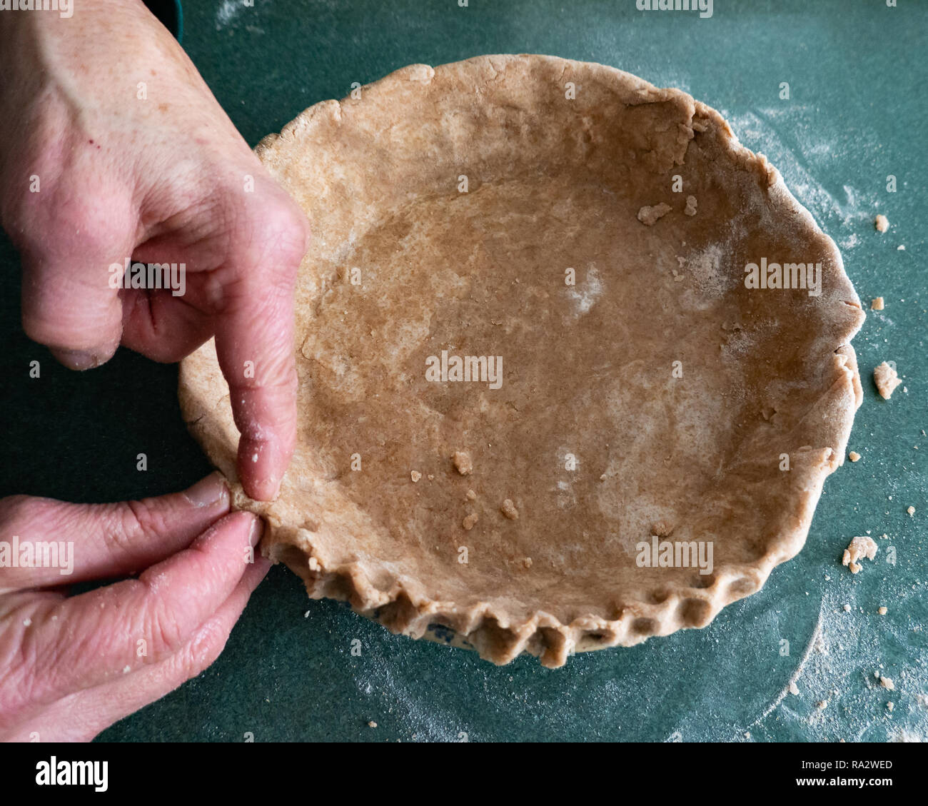A woman's hands making a whole wheat pie crust from scratch, the old fashioned way. Stock Photo