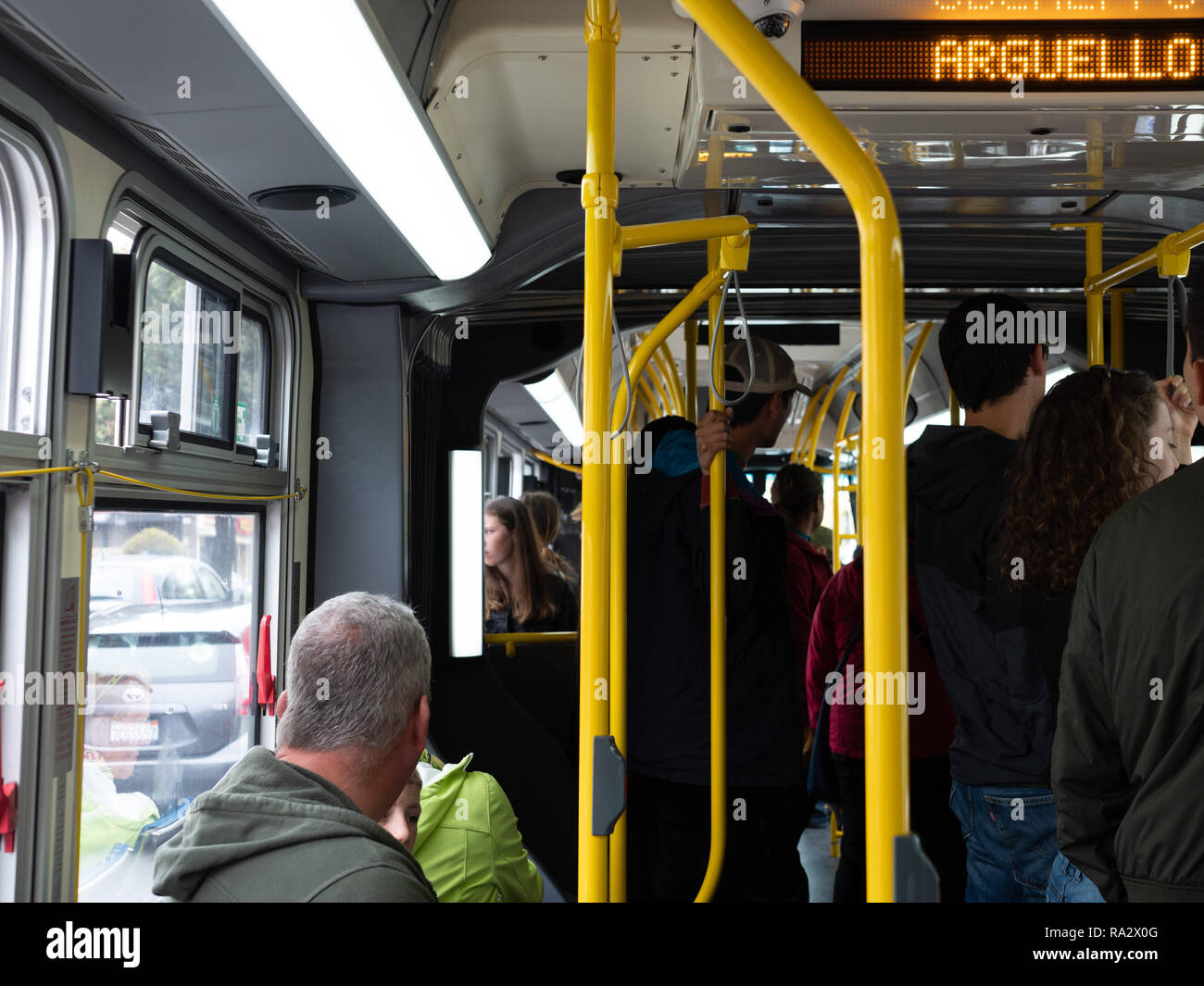 Crowded standing room only bus on 38 Geary line on MUNI crossing Arguello St Stock Photo