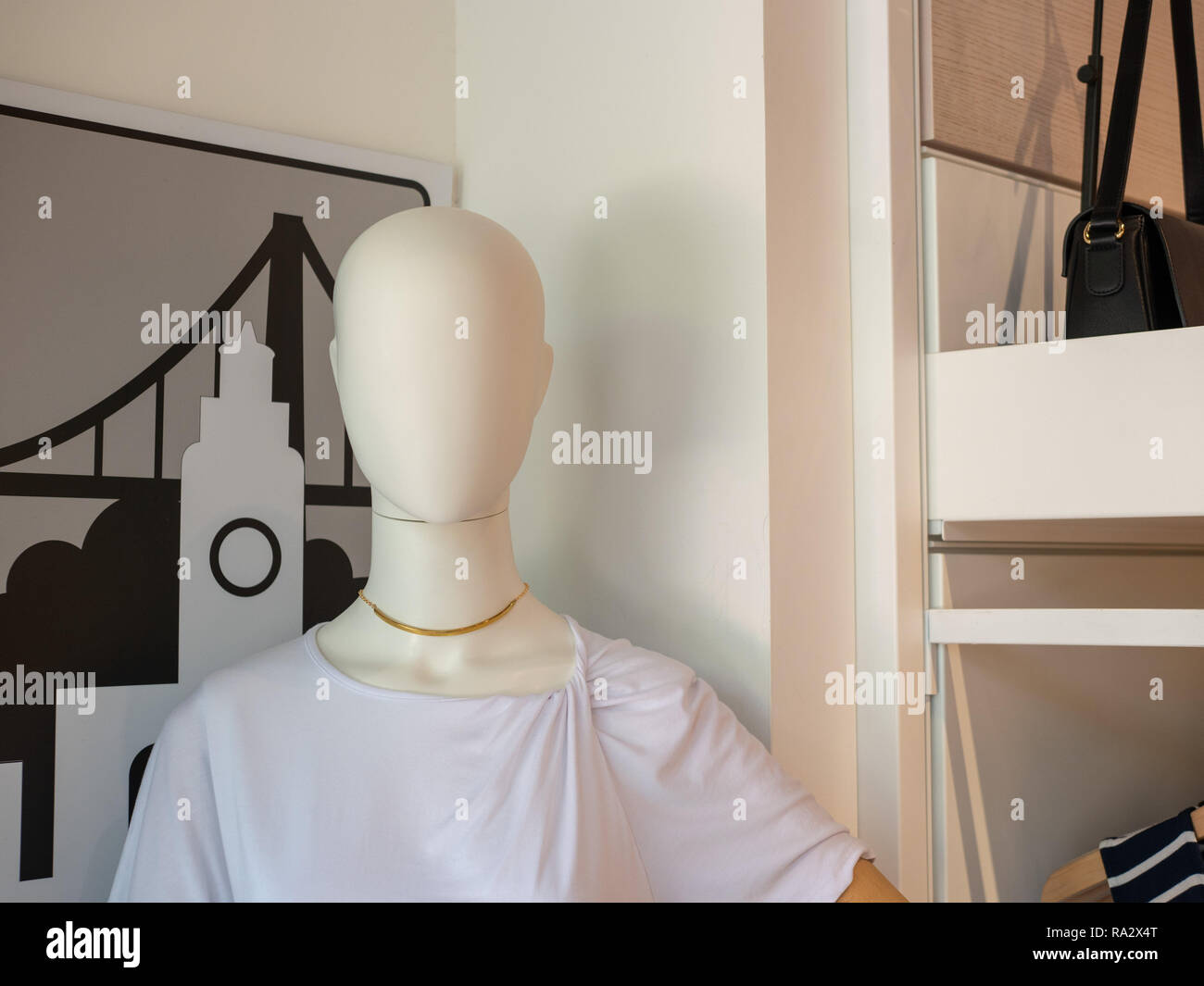 Female mannequin standing in storefront with blouse and inventory Stock