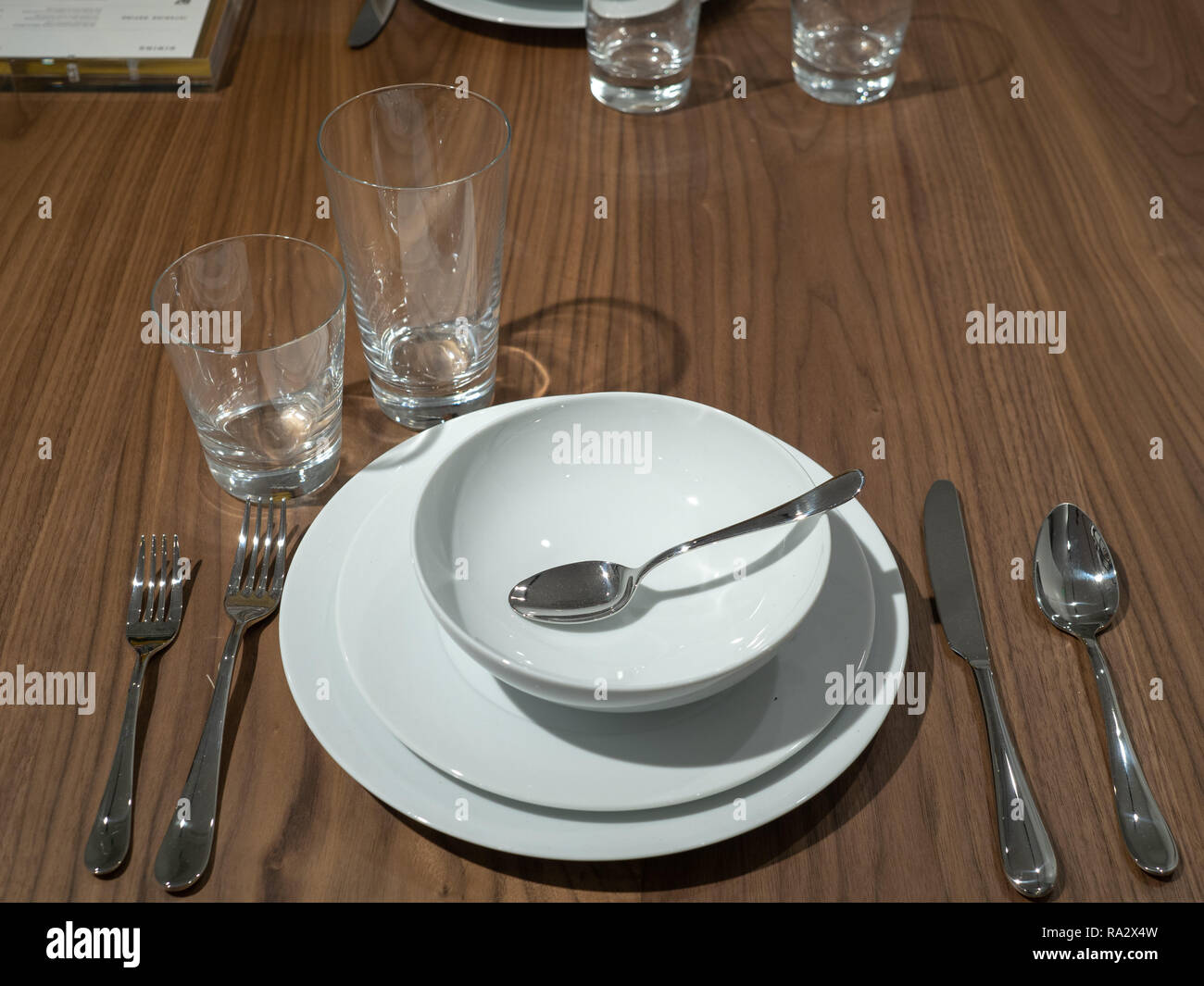 Dining set with utensils, bowls, and plates with over head light Stock Photo