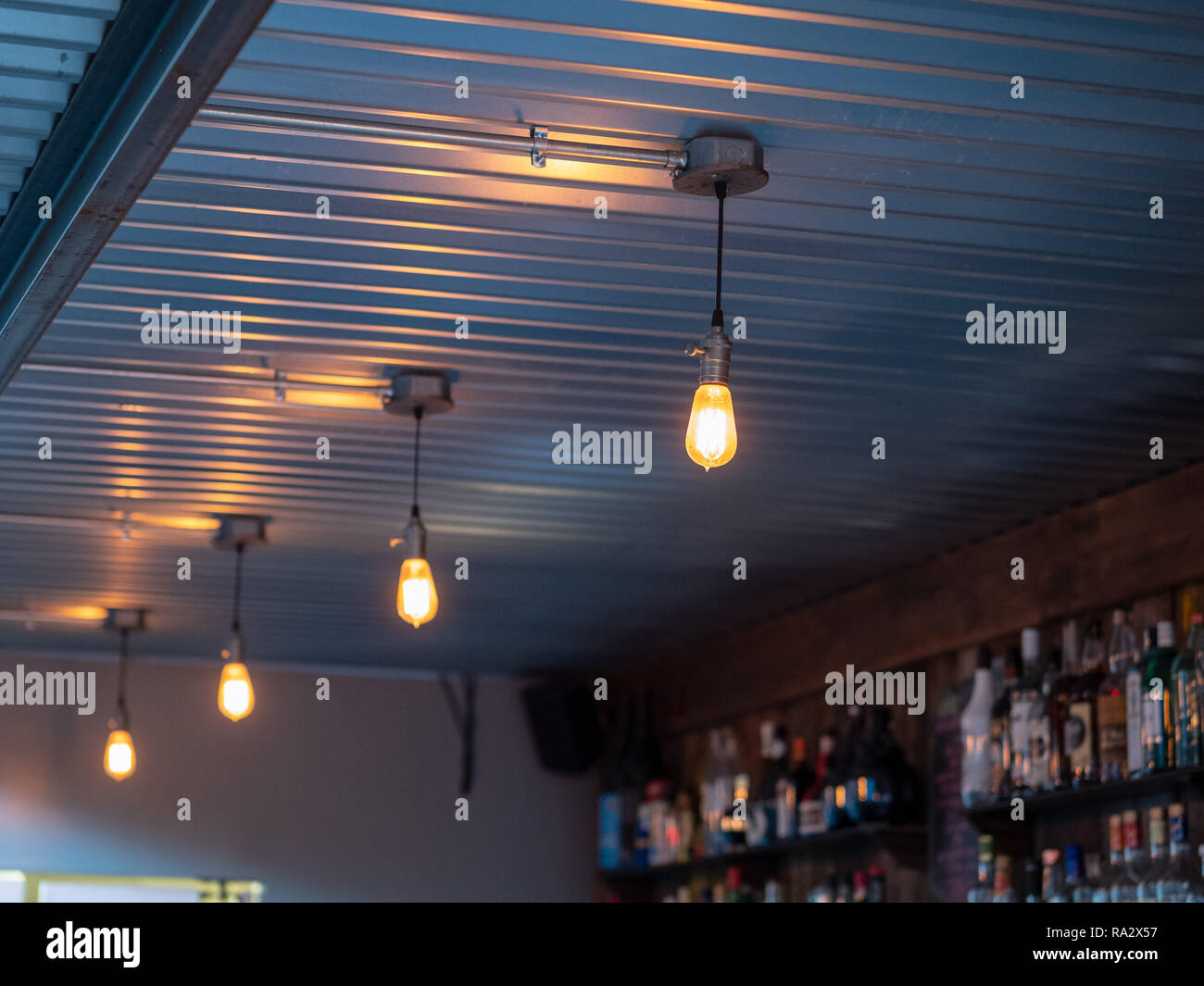 Line of overhead light bulbs in an industrial bar Stock Photo