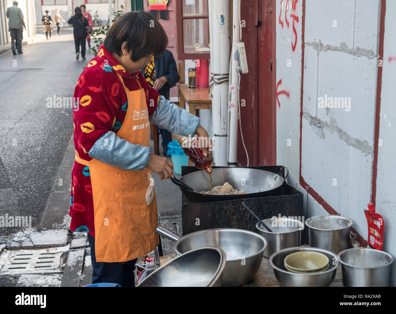 Woman on side of street cooking food in a wok Stock Photo Alamy