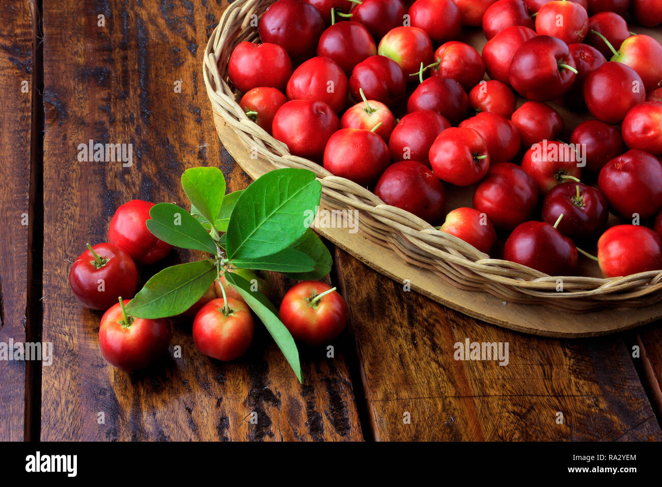 Acerola Cherry Raw Fresh In Basket With Heart Shape On Rustic Wooden acerola-cherry-raw-fresh-in-basket-with-heart-shape-on-rustic-wooden