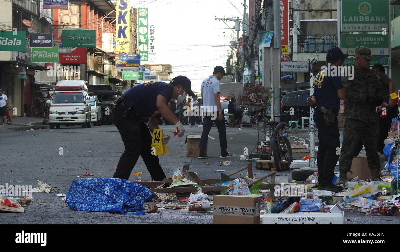 Cotabato City, Philippines. 31st Dec, 2018. Policemen gather evidence from the debris after a bombing at a mall in Cotabato City, the Philippines, Dec. 31, 2018. At least two people were killed and 21 others wounded, including a four-year-old girl, when an improvised explosive device (IED) exploded on Monday afternoon near the entrance of a mall in Cotabato City in the southern Philippines. Credit: Stringer/Xinhua/Alamy Live News Stock Photo