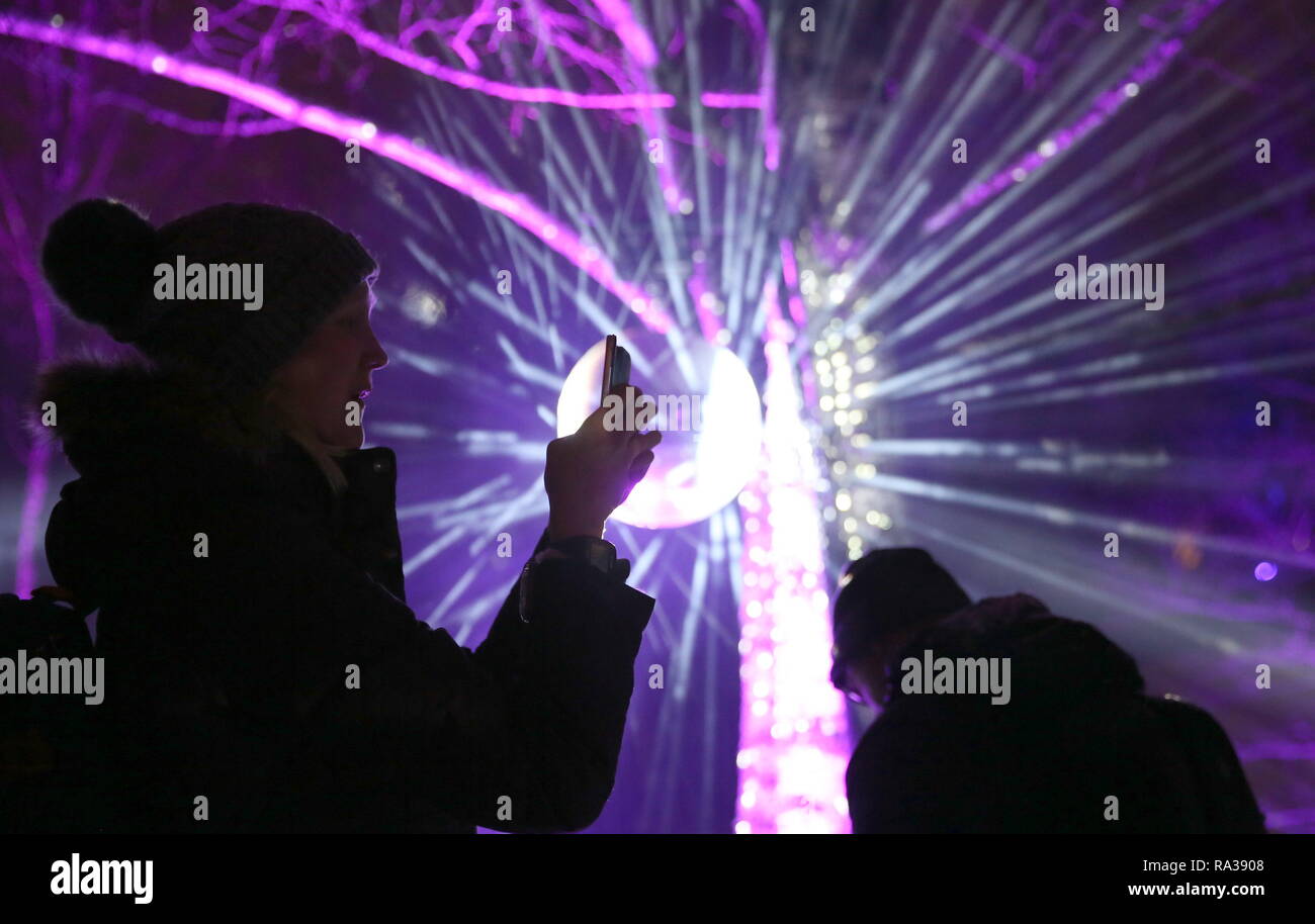 (190101) --ESPOO, Jan. 1, 2019 (Xinhua) -- People take selfies in the park decorated with light arts during a massive laser show held to celebrate the New Year in the city of Espoo, Finland, on Dec. 31, 2018. Espoo becomes the first city in Finland to replace fireworks with laser show when celebrating the New Year. The public demand for banning the use of fireworks is constantly rising in recent years in Finland, aiming to reduce the cases of injuries, air pollution and stress and anxiety in animals caused by fireworks. (Xinhua/Li Jizhi) Stock Photo