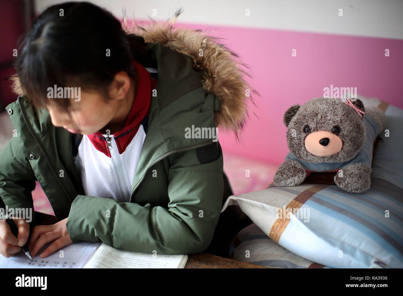 (190101) -- JULIAN, JAN. 1, 2019 (Xinhua) -- Jiang Qiao of the basketball team does her course assignment in her dormitory at Haoba central school in Junlian County of Yibin City in southwest China's Sichuan Province, on Dec. 8, 2018. Situated in the vast Wumeng Mountains of southwest China's Sichuan Province, Haoba central school is a nine-year school providing primary education and middle school education, just like other schools in this mountain area. However, a basketball team formed by female students made the school quite famous in its township, even in neighboring cities. The team was f Stock Photo