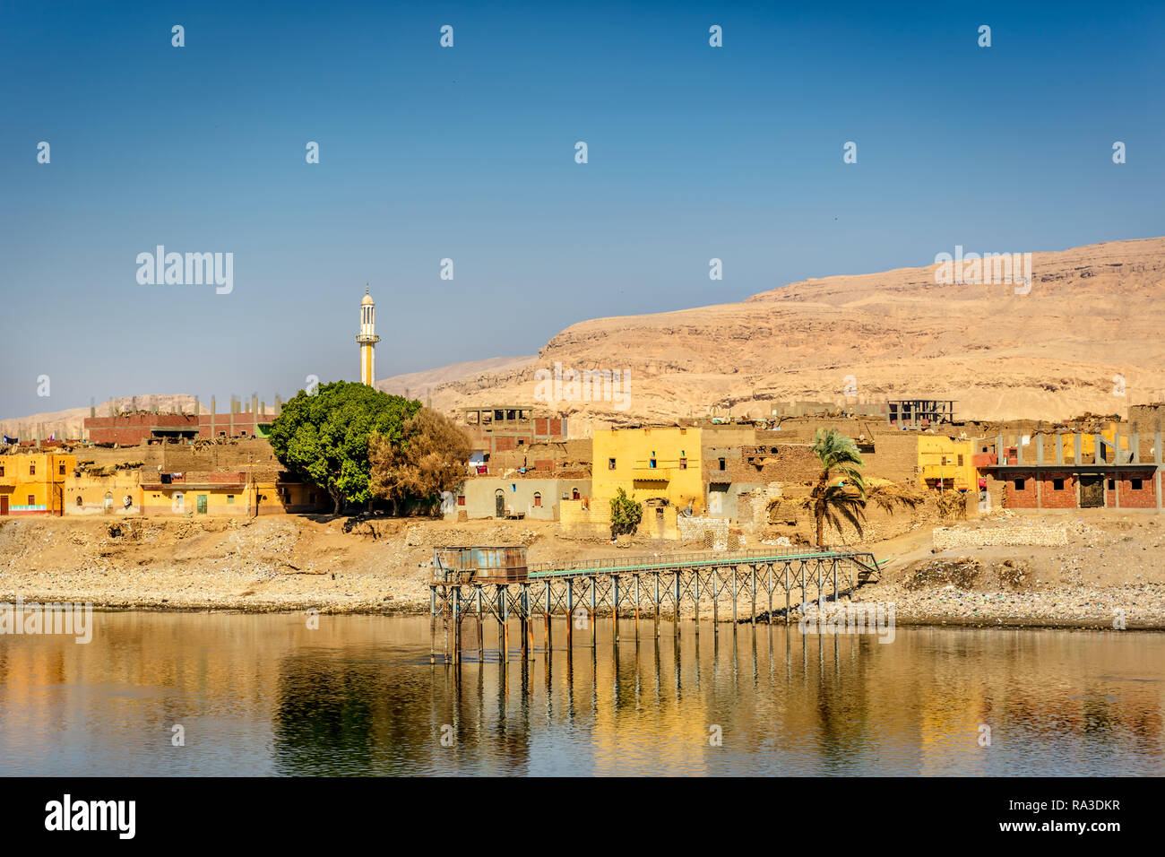 Nile river, Egypt - Nov 7th 2018 - Few houses and a mosque's minaret in the Nile river edge in a dry environment in Egypt Stock Photo