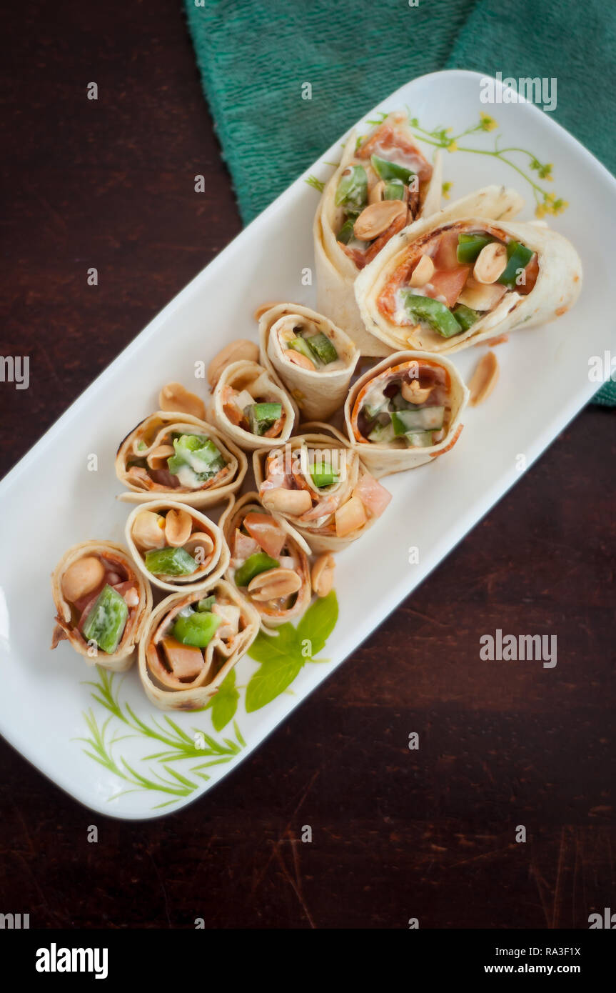 Sushi-Style Wraps with chicken pepperoni, vegetables and nuts. Healthy snacks. Stock Photo