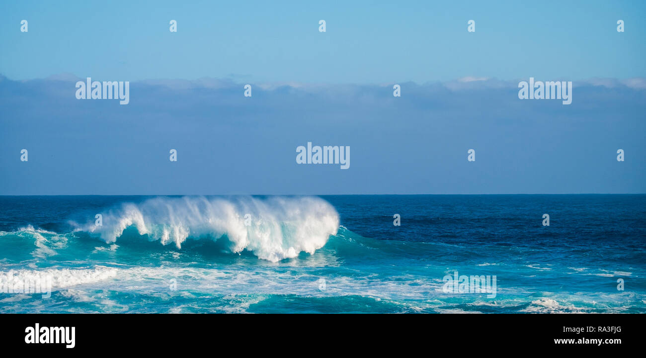 https://c8.alamy.com/comp/RA3FJG/big-wave-crash-in-the-middle-of-the-ocean-with-cliffs-and-coast-in-background-white-splash-for-big-swell-and-tide-perfect-for-surfers-dangerous-bl-RA3FJG.jpg